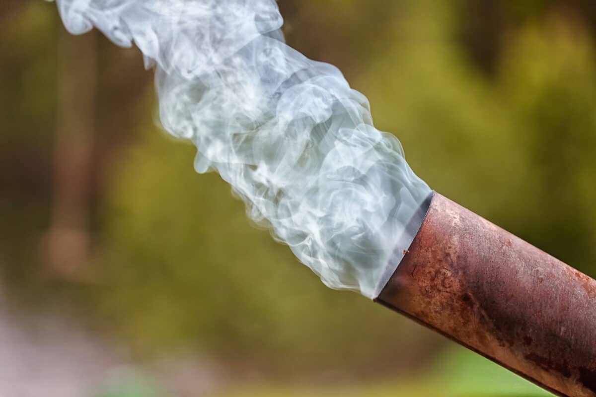 Smoke being emitted from a chimney showing the environmental impact of outdoor heaters.