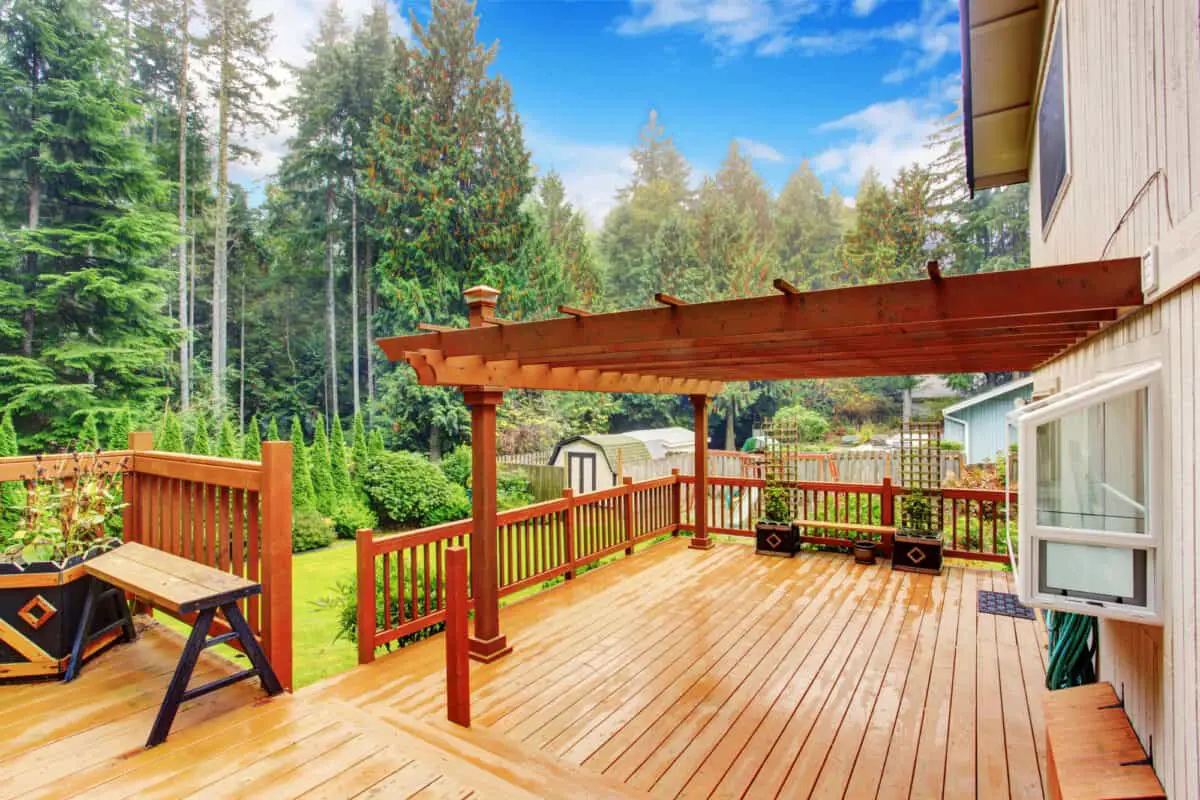 Spacious wooden deck with benches and attached pergola