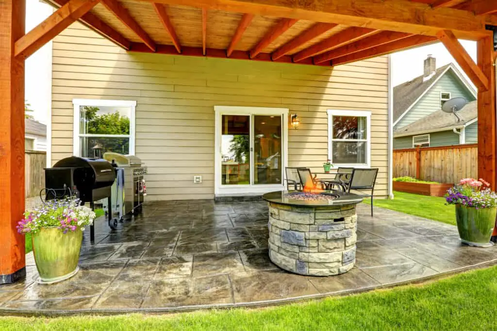 Example of a solid roof on a pergola covering backyard patio and attached to the house.