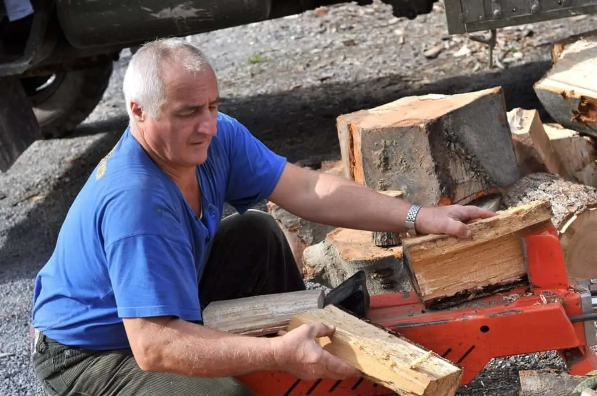 man showing log splitter safety while using a log splitter 