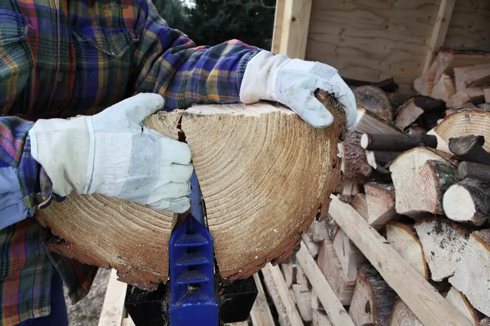 Close up of simple machine log splitter being used to split a large piece of wood.