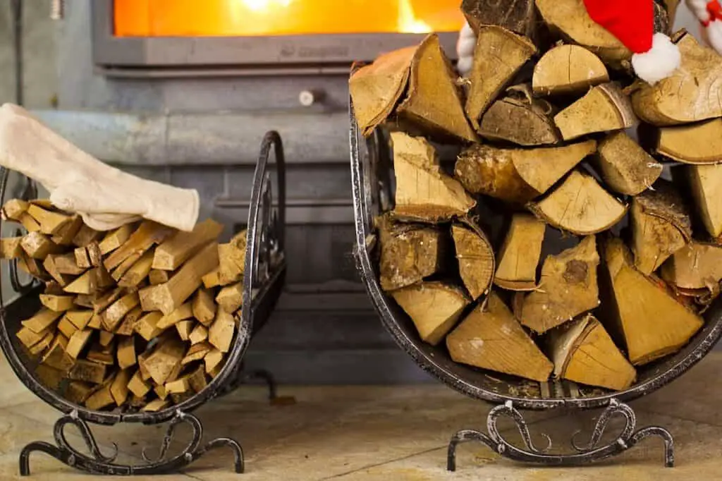 An example of one of the better indoor firewood storage solutions in front of a hearth with glowing fire.