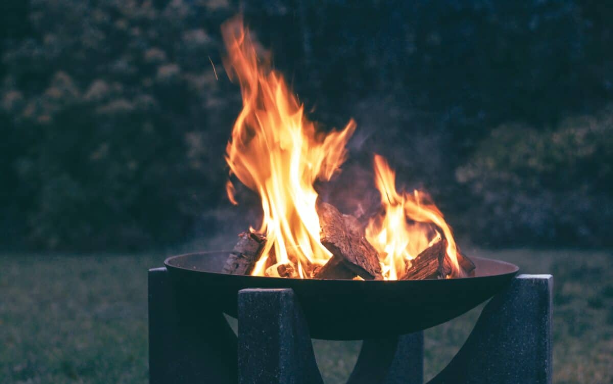 Fire pit in a fire bowl burning in a field showing if you need a fire ring.