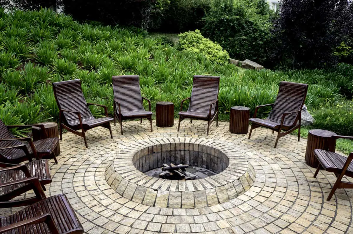 Fire pit on patio with rustic backyard chair showing good example to avoid fire pit patio damage.