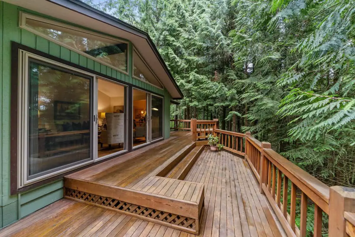 Beautiful deck surrounded by forest trees considering fire pit deck safety