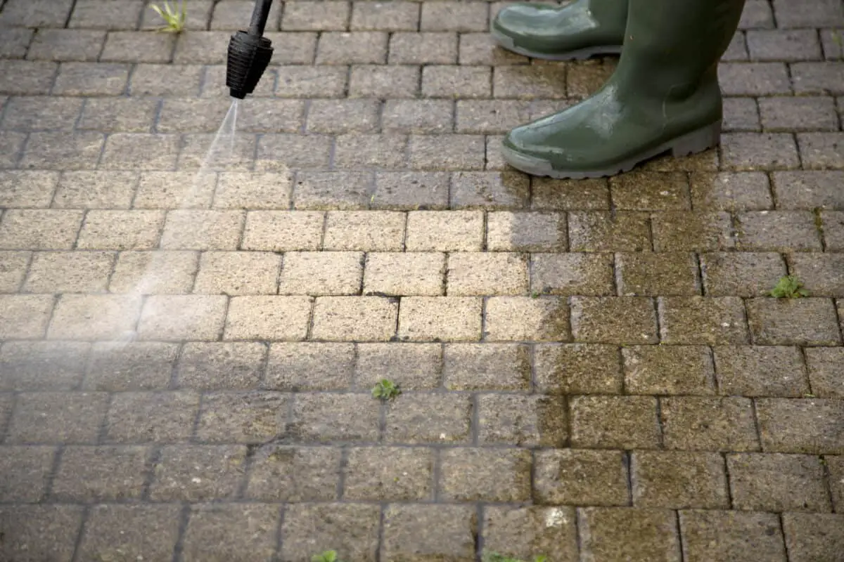 Outdoor floor cleaning showing pressure washing concrete.