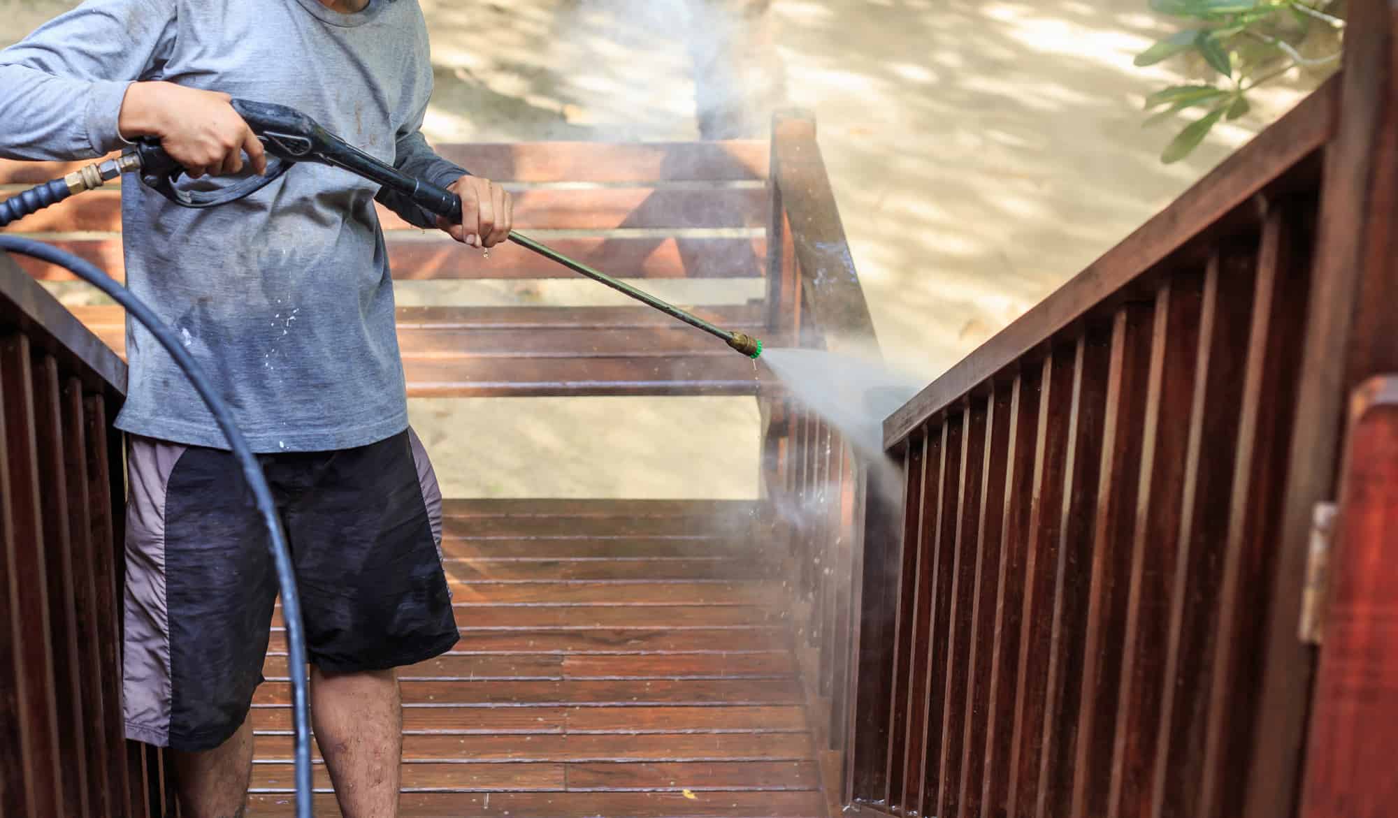 Man do a pressure washing on timber