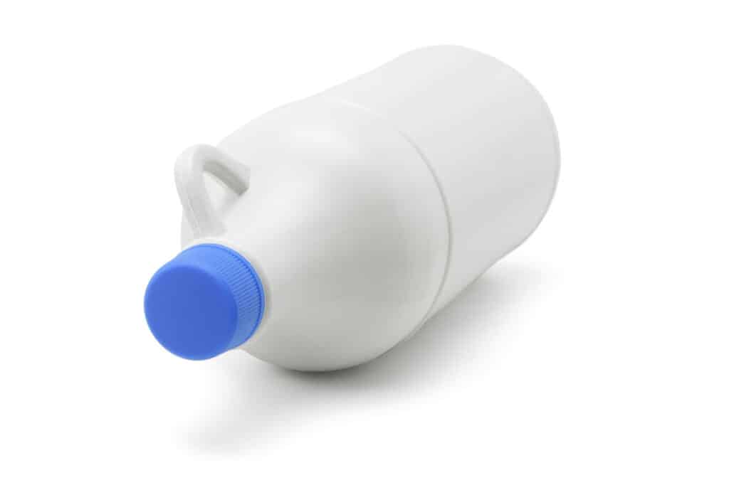 Plastic bleach bottle of household detergent lying on white background