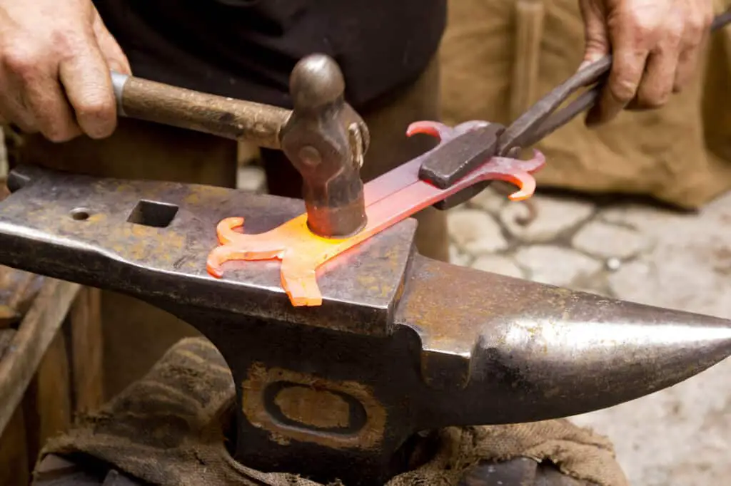 A blacksmith forged iron smith anvil hammerman traditional hammer beating.  Showing steel or wrought iron as best choice.