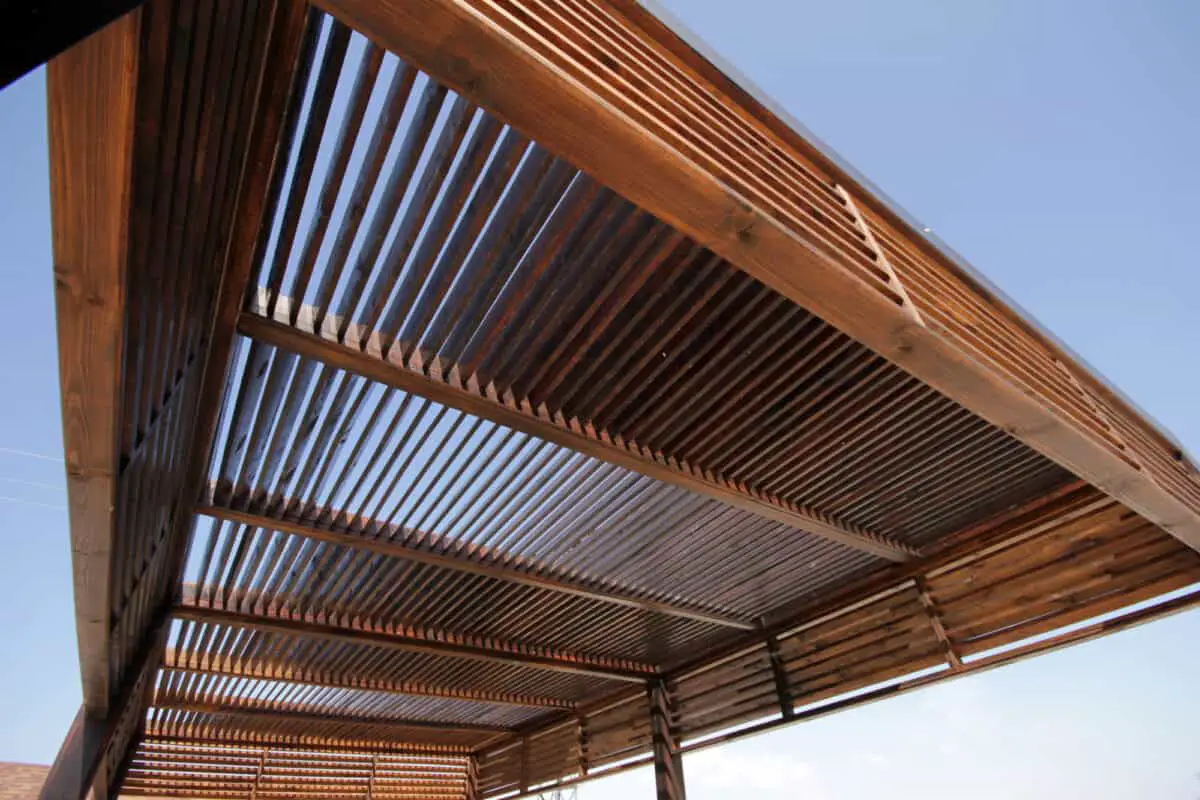 Close up of wooden louvered pergola with sky in background