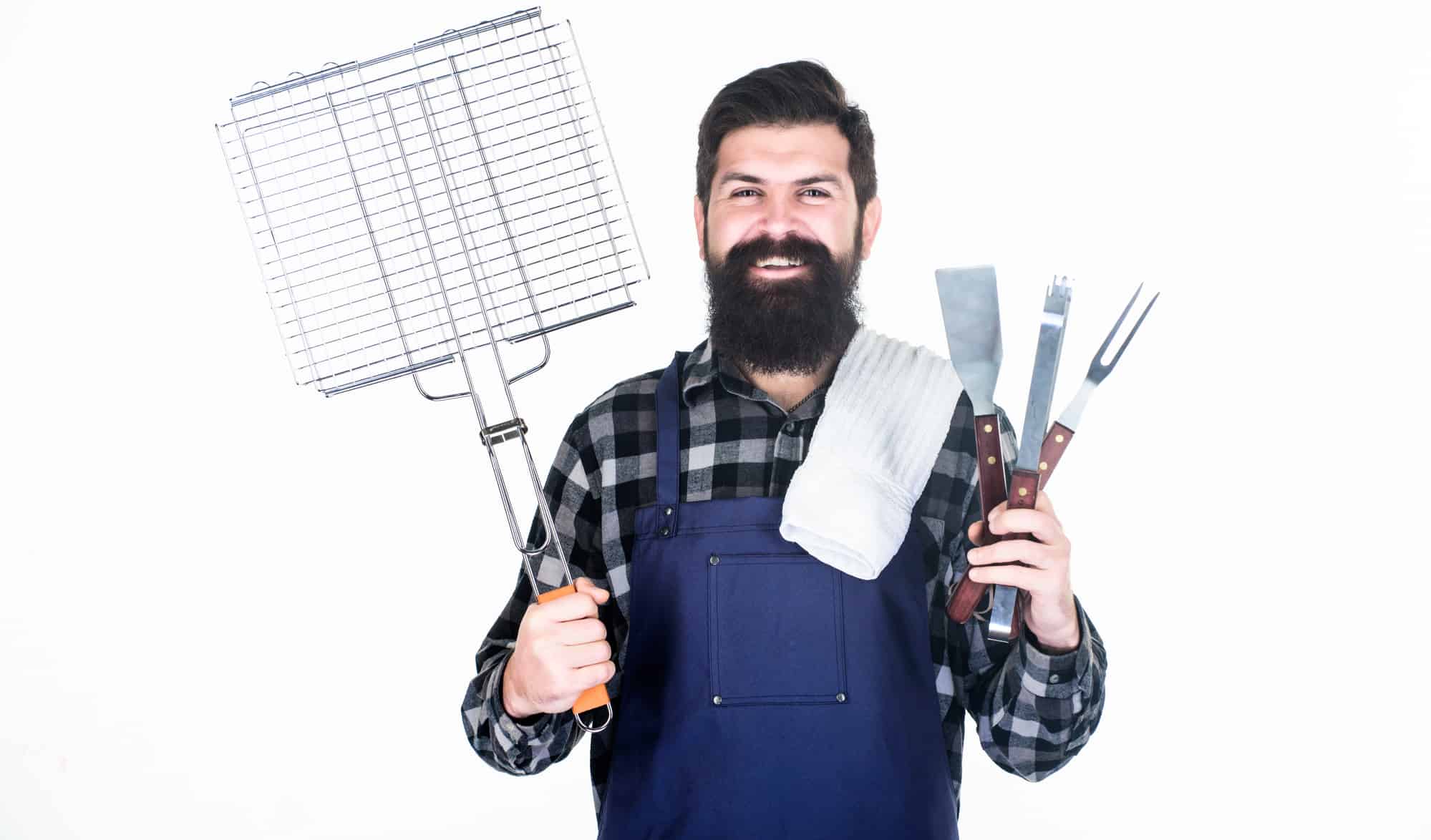 Your satisfaction guaranteed with cooking tool set. Happy hipster holding stainless steel tools. Bearded man with barbecue tools in hands. Grill cook using tool set with spatula and grilling fork.