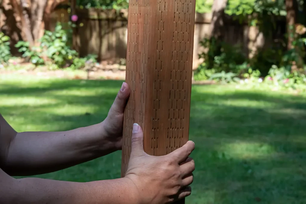 Man holding a 4x4 post for pergola post size