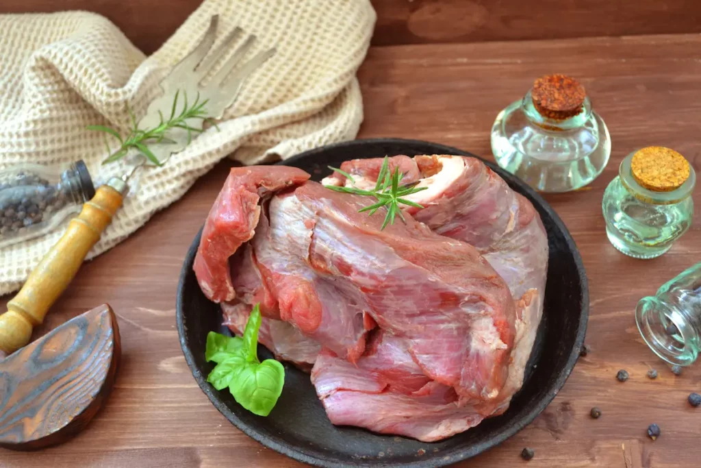 Traditonal raw moose meat sitting on a wooden table from moose meat in your freezer.