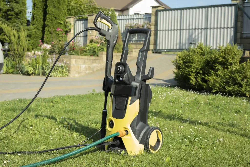 Reason to buy an electric pressure washer shown on a lawn outside a house. 