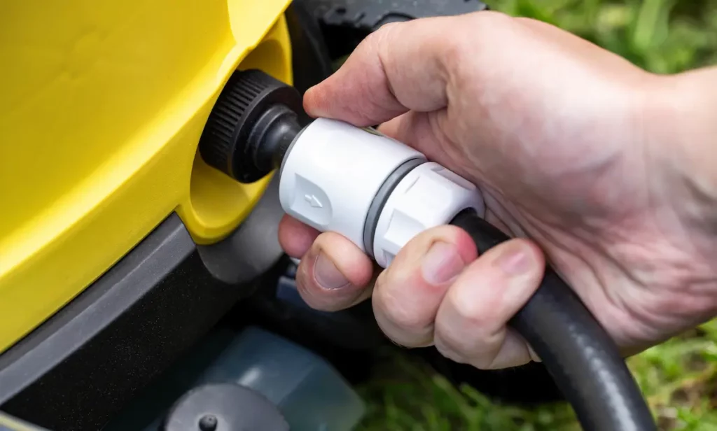 pressure washer hose being screwed onto power washer