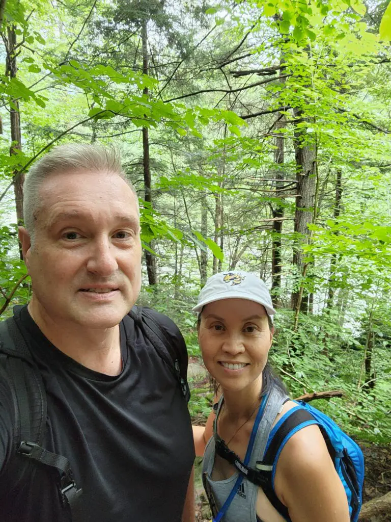 Image of Charlie and his wife hiking through woods.