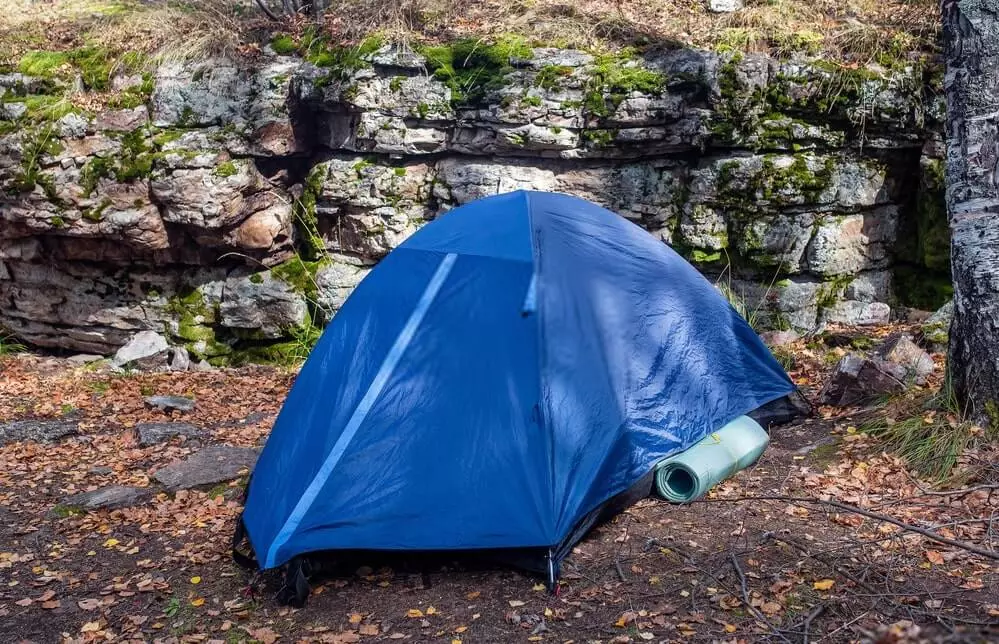 small camping tent near rocks